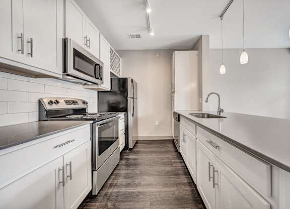 A kitchen with white cabinets and stainless steel appliances.at River Crossing Apartments, St. Charles, 63303
