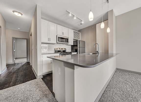A modern kitchen with a white countertop and cabinets.at River Crossing Apartments, Missouri, 63303
