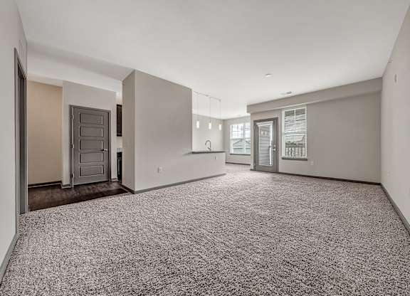 A spacious empty room with carpeted floor and white walls. at River Crossing Apartments, St. Charles, Missouri