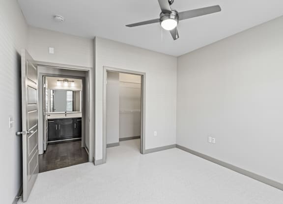 A room with a ceiling fan and two doors, one of which is open.at River Crossing Apartments, St. Charles