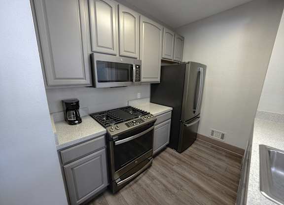 A kitchen with a stove, oven, microwave, and refrigerator at Rivers Edge Apartments, Waterford, MI