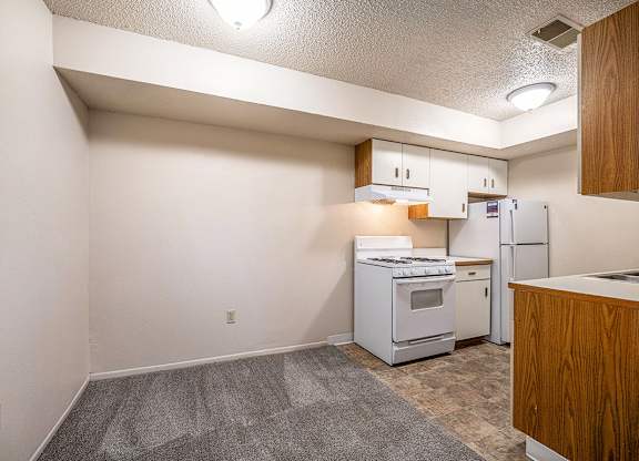 A kitchen with white appliances and a dining room at Seville Apartments, Michigan