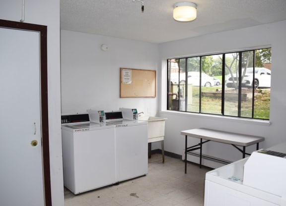 laundry room with a sink and a large window at Seville Apartments, Michigan