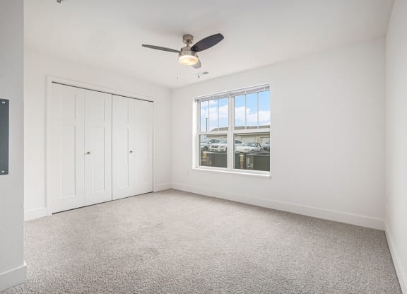 Bedroom with a ceiling fan and a large window  at Signature Pointe Apartment Homes, Athens, AL