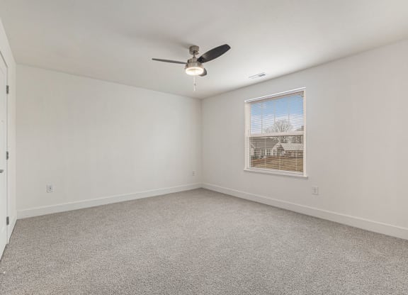 an empty bedroom with a ceiling fan and a window  at Signature Pointe Apartment Homes, Athens, 35611