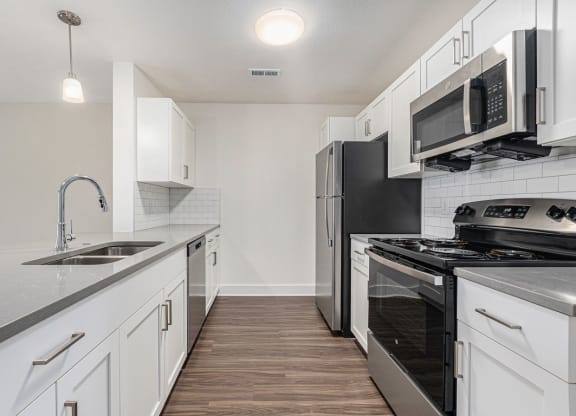 a kitchen with stainless steel appliances and white cabinets  at Signature Pointe Apartment Homes, Athens, Alabama