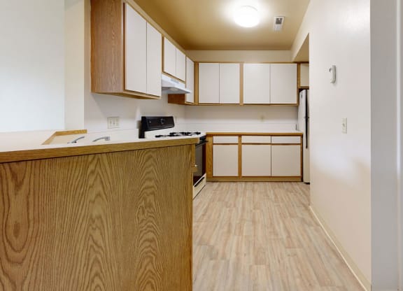 kitchen with a breakfast bar and closet at South Bridge Apartments in Fort Wayne, Indiana