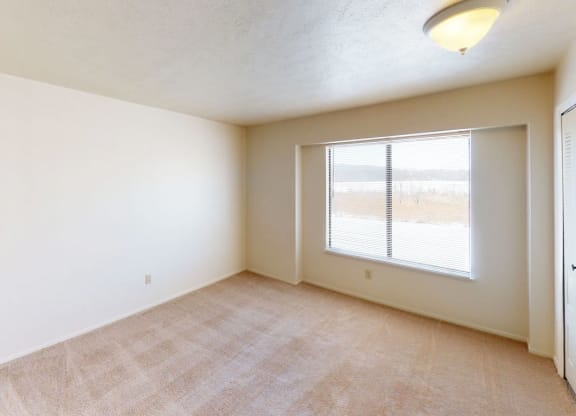 bedroom with a large window and a closet at South Bridge Apartments in Fort Wayne, Indiana