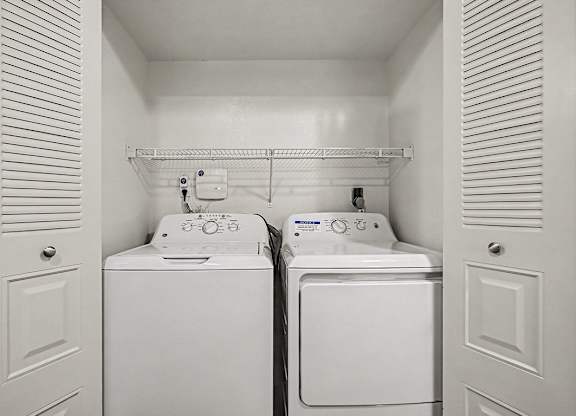 A small laundry room with a washer and dryer in it.