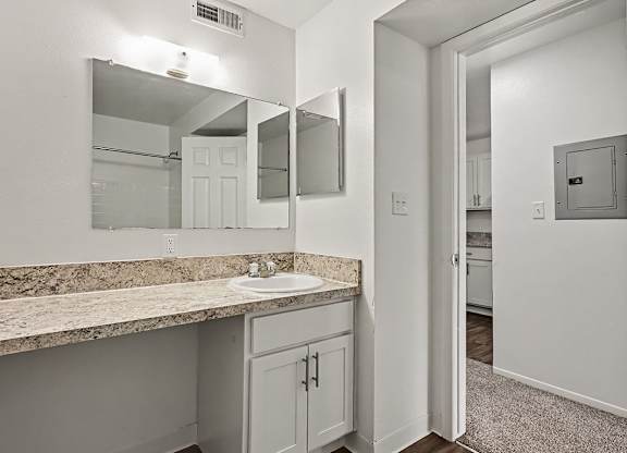 A bathroom with a sink, mirror, and medicine cabinet.