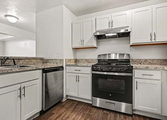 A kitchen with white cabinets and a black stove top oven.