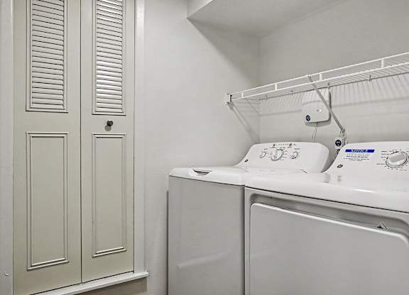 A white washing machine and dryer in a laundry room.