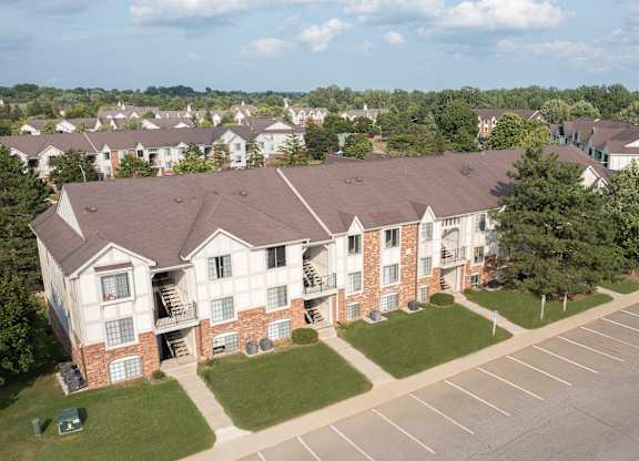 A large apartment complex with a parking lot in front.