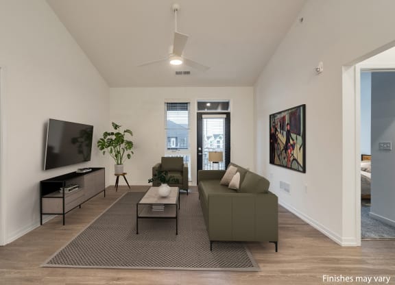 a living room with a couch and a coffee table in front of a tv  at Uptown Square Apartments, Troy