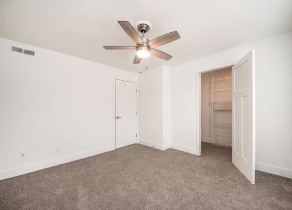Carpeted bedroom with a ceiling fan and a closet at Stoney Pointe Apartment Homes, Wichita, 67226