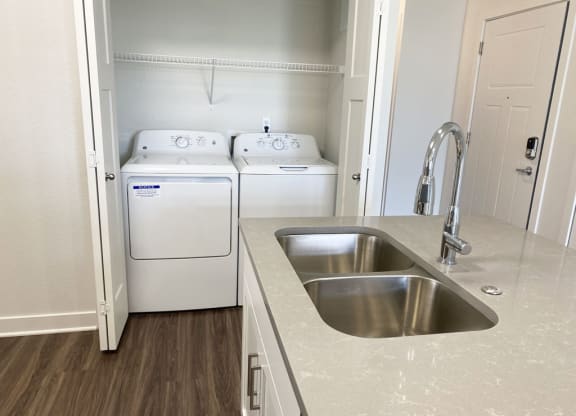 a kitchen with a sink and washer and dryer at Stoney Pointe Apartment Homes, Kansas