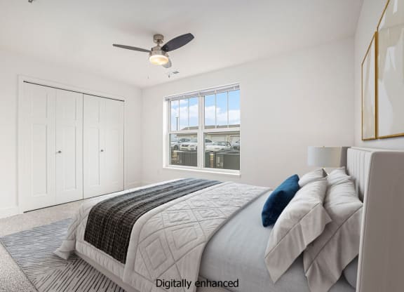 a white bedroom with a large bed and a ceiling fan at Stoney Pointe Apartment Homes, Wichita, KS