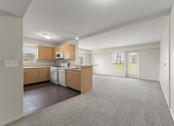 A kitchen with wooden cabinets and a white dishwasher at Stoney Pointe Apartment Homes, Kansas