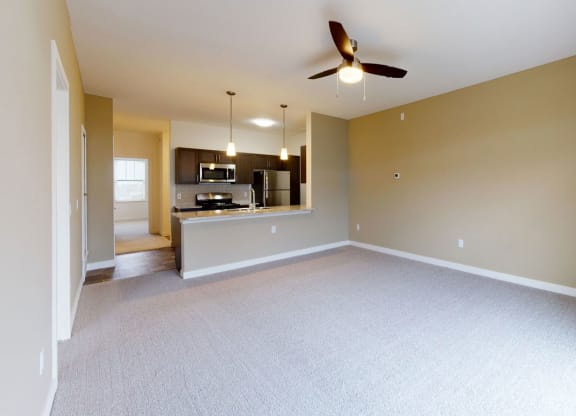 spacious living room with a ceiling fan and a kitchen at Strathmore Apartment Homes, West Des Moines, 50266