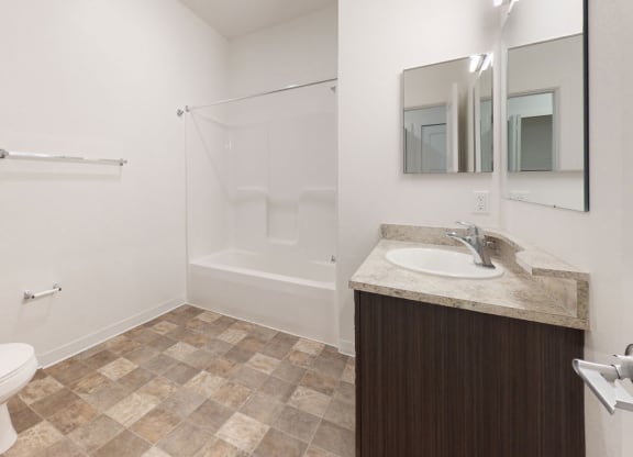 a bathroom with a toilet and a sink and a shower at Strathmore Apartment Homes, West Des Moines, 50266