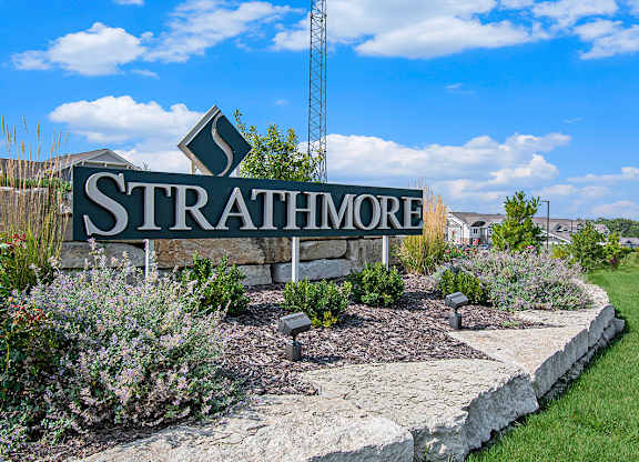 A sign that says Strathmore is in front of a grassy area at Strathmore Apartment Homes, Iowa
