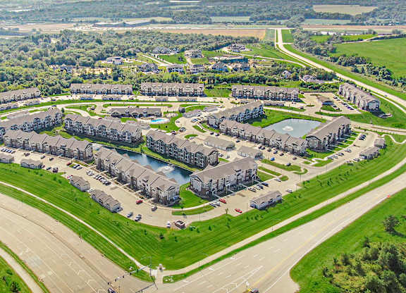 A large aerial view of an apartment community with multiple buildings at Strathmore Apartment Homes, Iowa