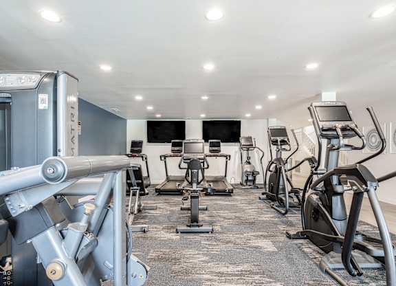 A gym with a variety of exercise equipment including treadmills, stationary bikes, and weight machines. at Sundance Apartments, Indiana, 46237