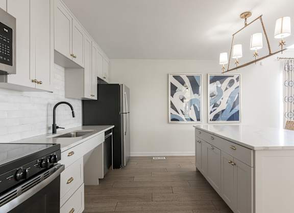 A kitchen with white cabinets and a black stove top oven. at Sundance Apartments, Indianapolis, IN