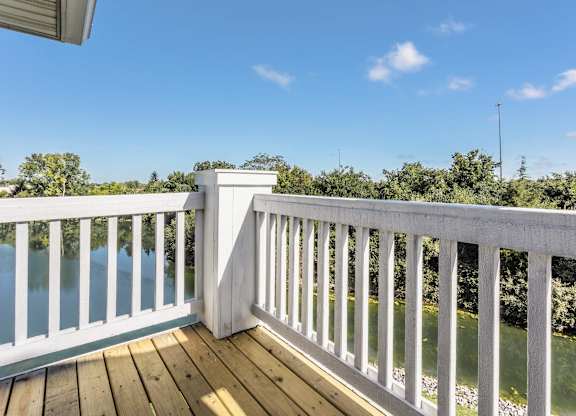A white railing overlooks a body of water. at Sundance Apartments, Indiana, 46237