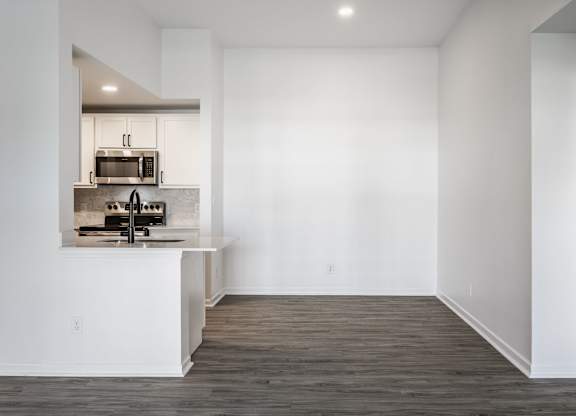 A kitchen with white walls and wooden floors. at Sundance Apartments, Indianapolis, 46237