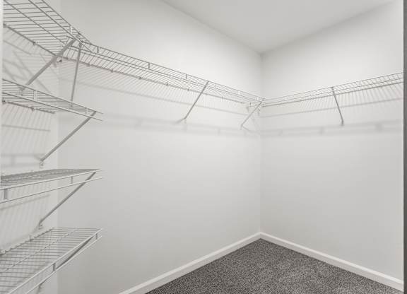A room with a grey carpet and metal shelving units. at Sundance Apartments, Indianapolis, Indiana