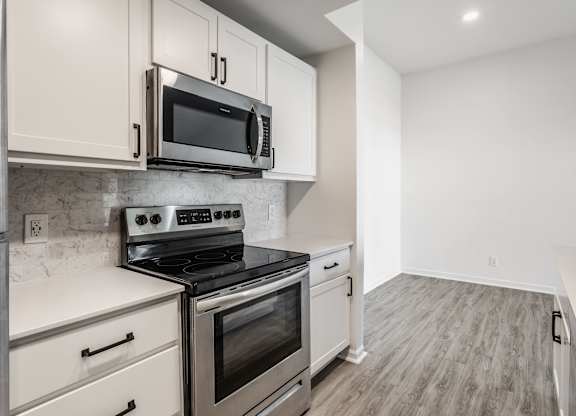 A kitchen with a stove top oven and microwave above it. at Sundance Apartments, Indianapolis, Indiana