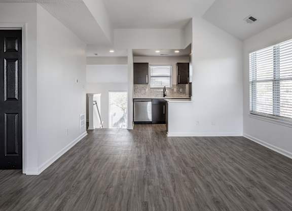 A spacious living room with a kitchen in the background. at Sundance Apartments, Indianapolis, Indiana