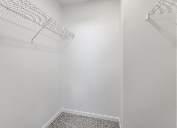 A white closet with a carpeted floor and two metal racks. at Sundance Apartments, Indianapolis, IN
