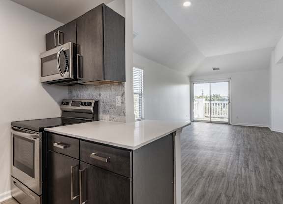 A modern kitchen with dark wood cabinets and stainless steel appliances. at Sundance Apartments, Indianapolis, IN