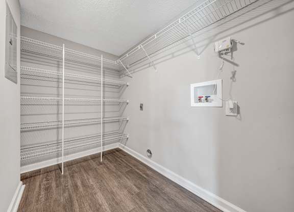 Empty walk-in closet with white shelves and wooden floors. at Sunscape Apartments, Roanoke, 24018