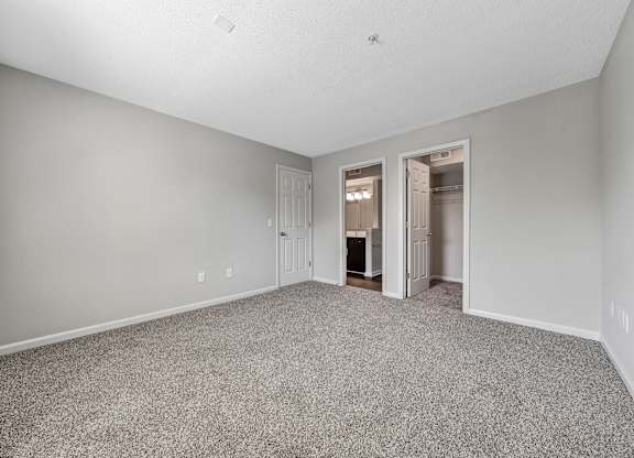 A spacious room with carpeted floor and two open doors. at Sunscape Apartments, Roanoke, Virginia