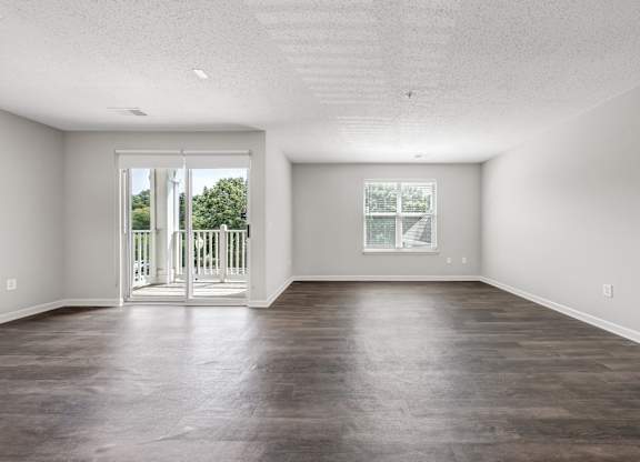 A large empty room with a sliding glass door. at Sunscape Apartments, Roanoke