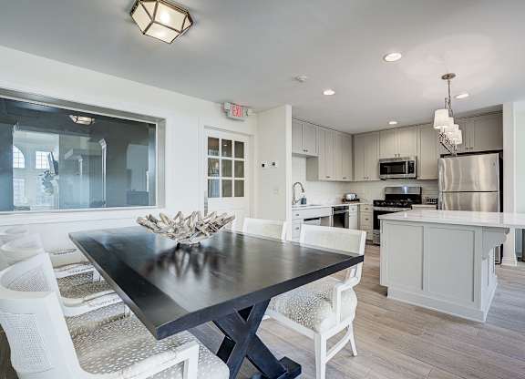 A modern kitchen with a dining table and chairs. at Sunscape Apartments, Roanoke, Virginia
