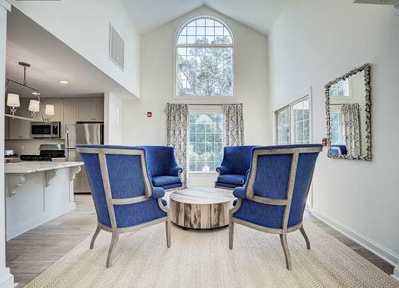 A living room with a blue chair and a coffee table. at Sunscape Apartments, Virginia, 24018