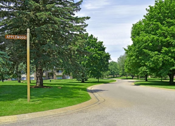 a street with trees on both sides and a street sign in the middle of the road  at Sycamore Creek Apartments, Michigan