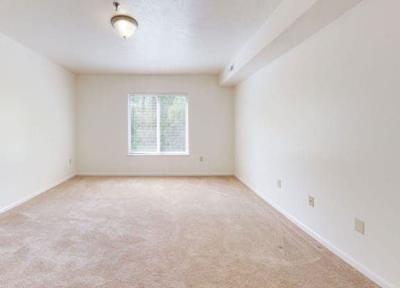an empty bedroom with a window at Tall Oaks Apartment Homes, Kalamazoo, 49009