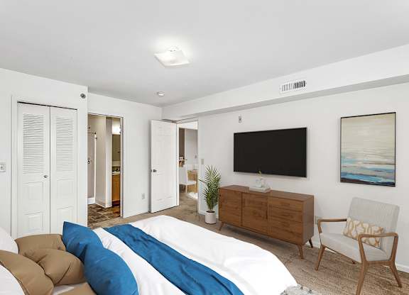 a bedroom with a large bed and doors to a closet and bathroom at Tall Oaks Apartment Homes, Michigan