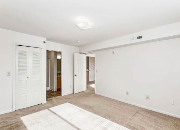 A spacious bedroom with an ensuite and a door to a walk-in closet at Tall Oaks Apartment Homes, Kalamazoo, MI, 49009