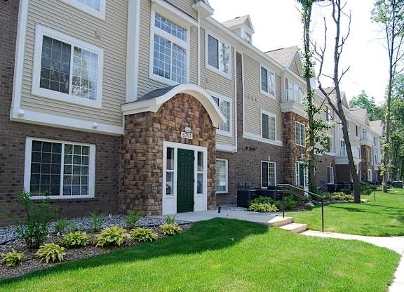 Apartment building with a green lawn in front at Tall Oaks Apartment Homes, Kalamazoo, MI, 49009