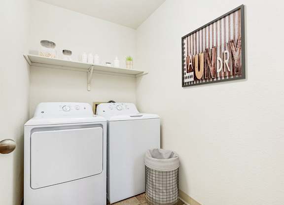A laundry room with a washer and dryer and a shelf at Tanglewood Apartments, Oak Creek