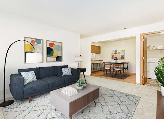 A living and dining room with a couch, table, and a rug at Tanglewood Apartments, Oak Creek