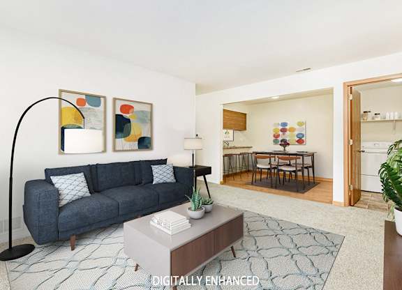 A living and dining room with a couch, table, and a rug at Tanglewood Apartments, Oak Creek