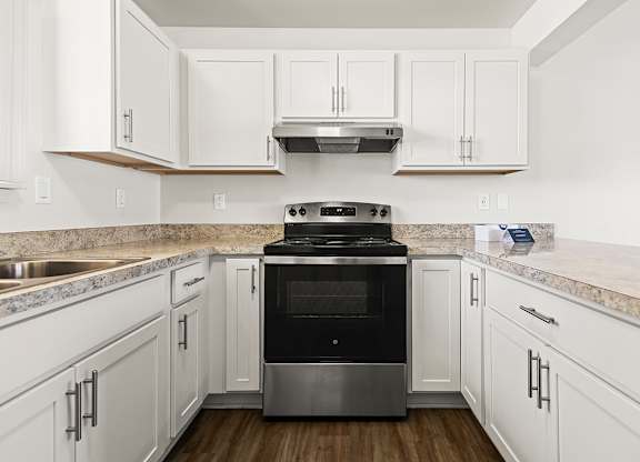 A modern kitchen with white, shaker-style cabinets and a stainless steel oven at Tanglewood Apartments, Oak Creek, WI
