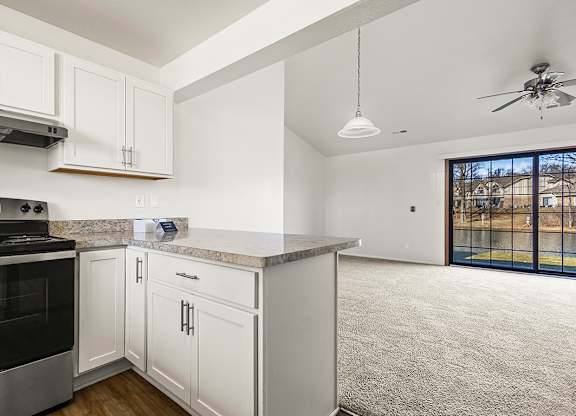 A kitchen with white cabinets and a breakfast bar at Tanglewood Apartments, Oak Creek, WI